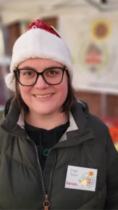 Eine Person mit Nikolausmütze schaut freundlich in die Kamera