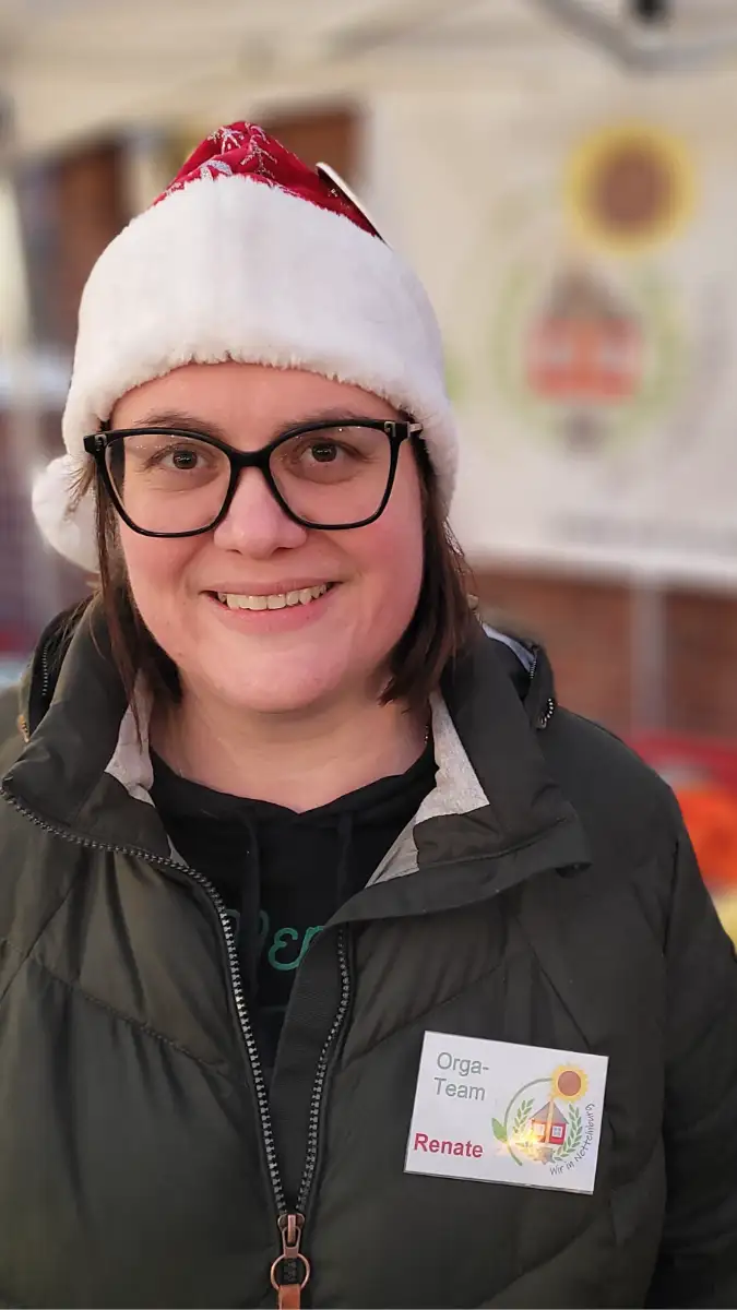 Eine Person mit Nikolausmütze schaut freundlich in die Kamera