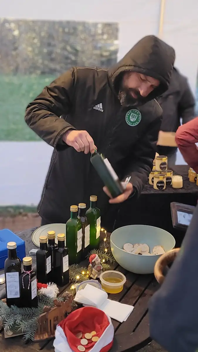 Eine Person steht an einem Glühweinstand.